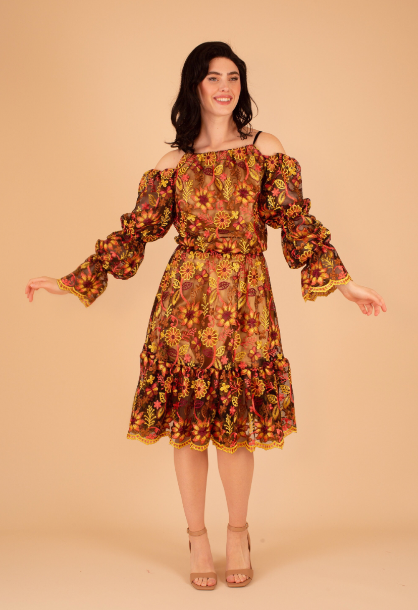 Woman wearing a floral off-shoulder dress on a beige background