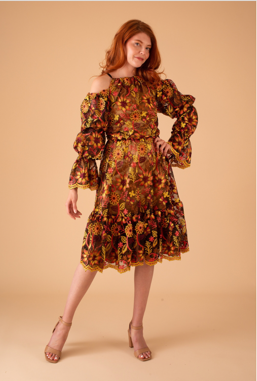 Woman wearing a floral off-shoulder dress on a beige background